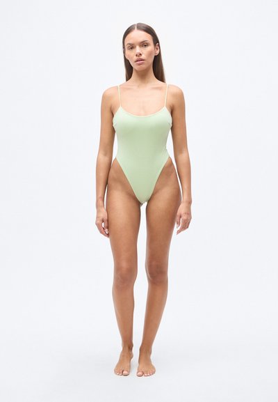 Φωτεινό πράσινο ολόσωμο μαγιό με λεπτές τιράντες, λαιμόκοψη scoop, ψηλό κόψιμο στα πόδια και λεία υφή. Μινιμαλιστικός σχεδιασμός χωρίς ορατά σχέδια.