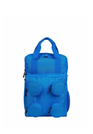 Sac à dos bleu avec quatre compartiments ronds en relief portant le logo LEGO à l'avant et deux petites poignées en haut sur fond blanc.