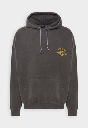 Tummanharmaa huppari, jossa etutasku, kiristysnauhat ja keltainen "BDG JEANS" -kirjailu, johon kuuluu logo ja laakeriseppeleen kuvio.