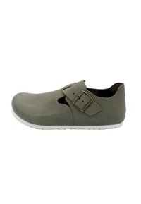 Olivgrüne Clogs aus Gummi mit runder Zehenpartie, Riemen und metallischem Schnallen-Detail sowie einer weißen strukturierten Laufsohle.