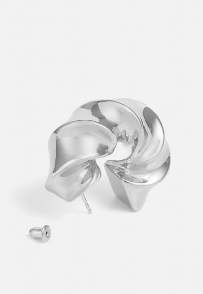 Silver skulpturörhänge med en vriden design och en slät, reflekterande yta. Inkluderar en bakkomponent för säkerhet.