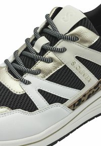 Sneaker a rete bianco e nero con accenti dorati, caratterizzati da materiali testurizzati, dettagli laterali a disegno e lacci bianco e nero.