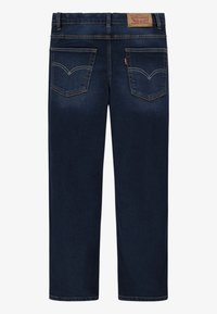 Jeans in denim blu scuro con un design a gamba dritta, caratterizzati da tasche posteriori con cuciture curve e un’etichetta in pelle color nocciola in vita.