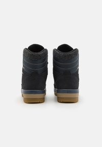 Dark blue high-top sneakers with a textured suede finish, featuring a cushioned collar and rubber sole, accented by beige and gray details.