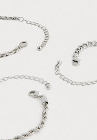 Ezüst lánc karkötők különböző dizájnnal, beleértve a csavart és láncolt stílusokat, rákcsipeszes zárakkal és kerek gyöngyökkel.