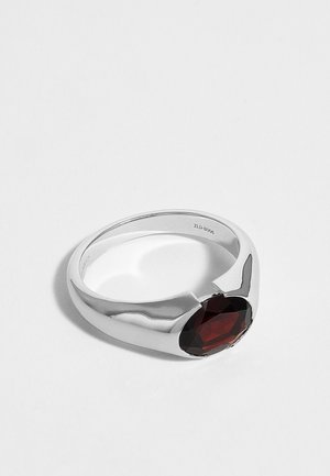 Silberner Ring mit polierter Oberfläche mit einem großen ovalen dunkelroten Edelstein in teilweiser Fassung.