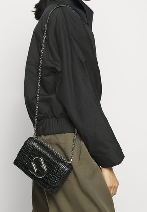 Sort struktureret læder crossbody taske med sølvhardware og kædestrop, med klaplukning og præget mønster.