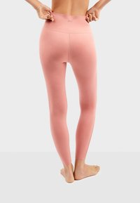 Roze leggings van rekbare stof, met een hoge tailleband, een soepele textuur en zonder zichtbare patronen of versieringen.