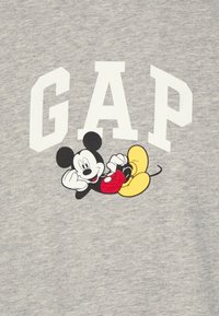 Grå sweatshirt med stort hvidt "GAP" tryk og en tegneseriefigur af Mickey Mouse i rød og gul, med korte ærmer og rund halsudskæring.