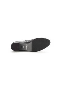 Zapato de cuero negro con suela texturizada, puntera ligeramente redondeada y tacón bajo. Nombre de la marca "Gabor" impreso en la suela.