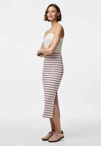 Svītraina zīmuļu svārki gaisīgi rozā ar tumšām svītrām, ar sānu šķēlumu. Apvienoti ar rozā sporta apaviem, valkāti ar bezpiedurkņu baltu topiņu.