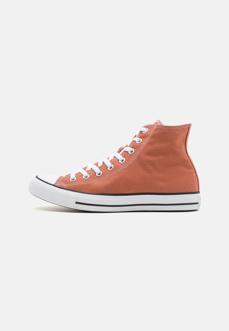 Basket montante en toile orange atténuée avec des lacets blancs, un embout en caoutchouc blanc et une semelle blanche à rayures noires.