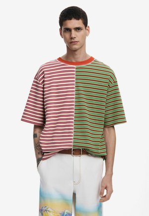 Kortærmet, stribet strik T-shirt med et opdelt design i røde og grønne nuancer samt orange halsudskærmningsdetaljer. Løs pasform og afslappet tekstur.