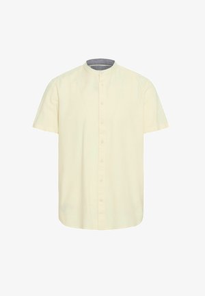 Chemise à manches courtes en coton jaune pâle, avec un col mandarin, des boutons à l'avant et un col intérieur gris contrastant.