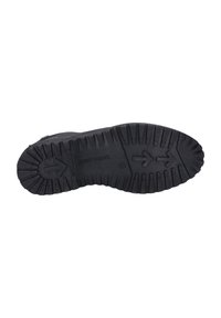 Suela de zapato de goma negra con un patrón de textura, que presenta flechas direccionales y el nombre de la marca "Josef Seibel" en relieve.