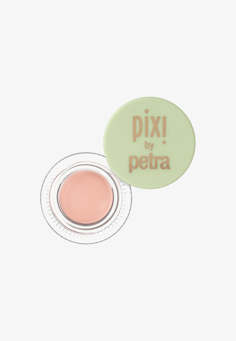 Pfirsichfarbener Creme in einem klaren Glas mit geriffeltem Boden, bedeckt mit einem runden grünen Deckel, auf dem der erhabene rosa Text "pixi by petra" prangt.