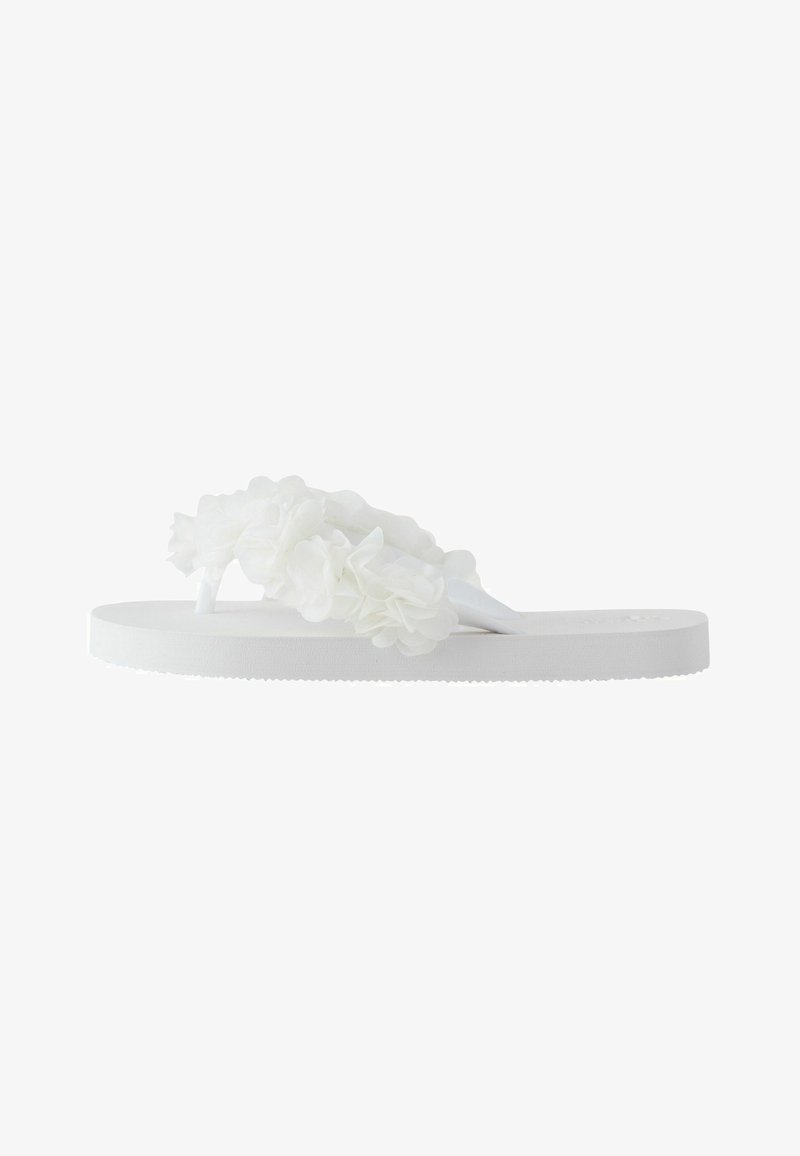 Claquette blanche à semelle épaisse, décorée de plusieurs fleurs en tissu blanc sur la bride.