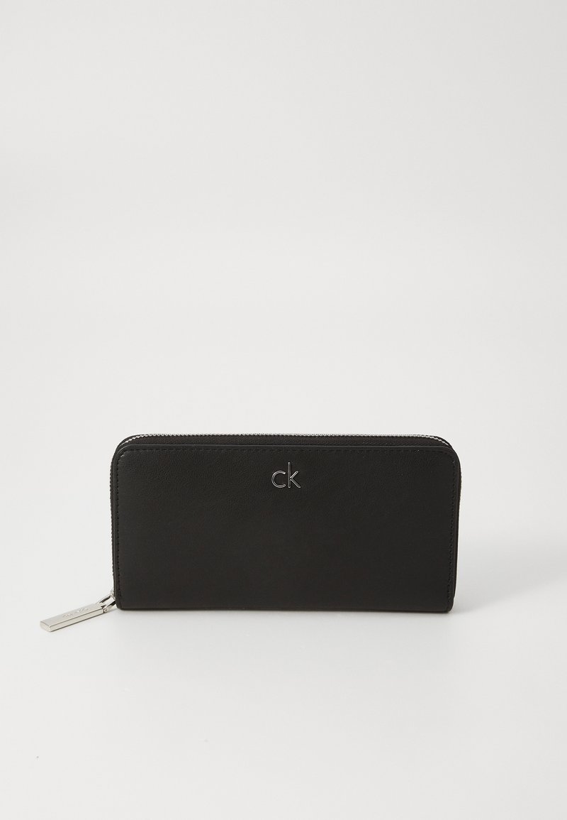 Portofel din piele neagră, cu un design rectangular elegant, având logo-ul embosat "ck" pe față și un fermoar cu mânere argintii.