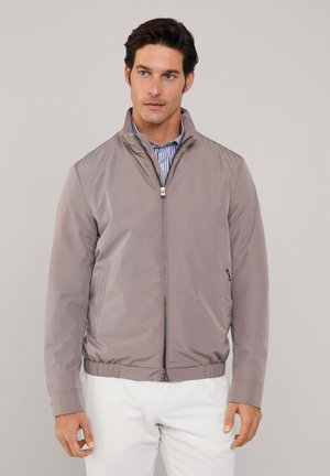 Lichtgewicht, taupe kleurige zip-up jas met een staande kraag en elastische zoom. Gladde, glanzende stof met zijzakken en een minimalistisch ontwerp.