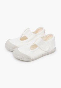 Witte canvas schoenen met een rubberen zool, met een uitgesneden ontwerp en klittenbandsluiting. Geweven neuskap en zijkanten.