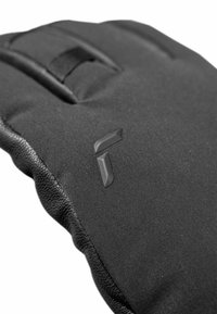 Schwarzer gepolsterter Handschuh mit strukturierten Seiten, mit einem hervorgehobenen Logo-Akzent. Das Material wirkt synthetisch mit einer glatten Oberfläche und verstärkten Nähten.