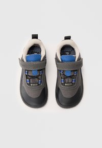 Scarpe per bambini grigie e nere con superficie testurizzata, cinturino in Velcro e dettagli blu. Presentano il marchio impermeabile Gore-Tex.