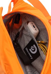 Helle orange Rucksack-Innenseite mit einem hellgrauen Innenfutter und einem topografischen Muster; verfügt über eine Tasche für elektronische Geräte und Kabel.