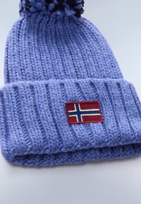 Berretto viola lavorato a maglia con risvolto, caratterizzato da una toppa rettangolare rossa con il design della bandiera norvegese e un pompon nero sulla parte superiore.