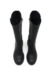 Botas altas de piel negra con un acabado suave, que cuentan con punta redondeada, cremalleras laterales y suelas de goma texturizada.