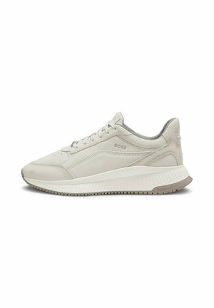 Zapatilla baja color beige claro con cordones delanteros, suela texturizada y sutil marca "BOSS" en el lateral y el talón.