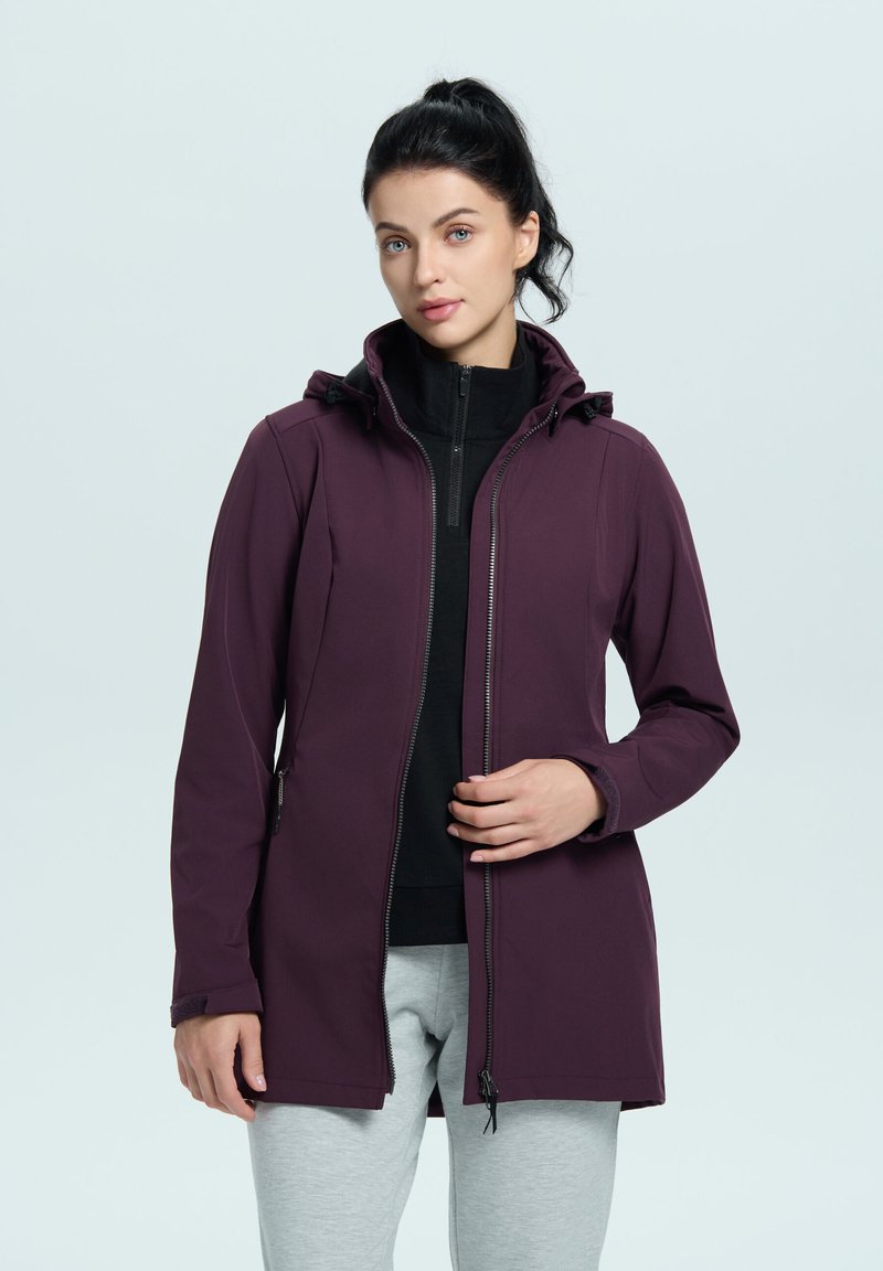 Giacca softshell viola con cappuccio, chiusura frontale con zip e tasche laterali, indossata sopra una maglietta nera e pantaloni grigi. Texture liscia, design moderno.