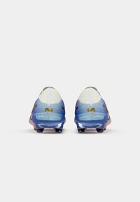 Fudbalske kopačke s gradijentnim dizajnom u plavoj i ružičastoj boji, mrežasta tkanina na peti i sjajna potplat. Zlatni logo na bočnim stranama.