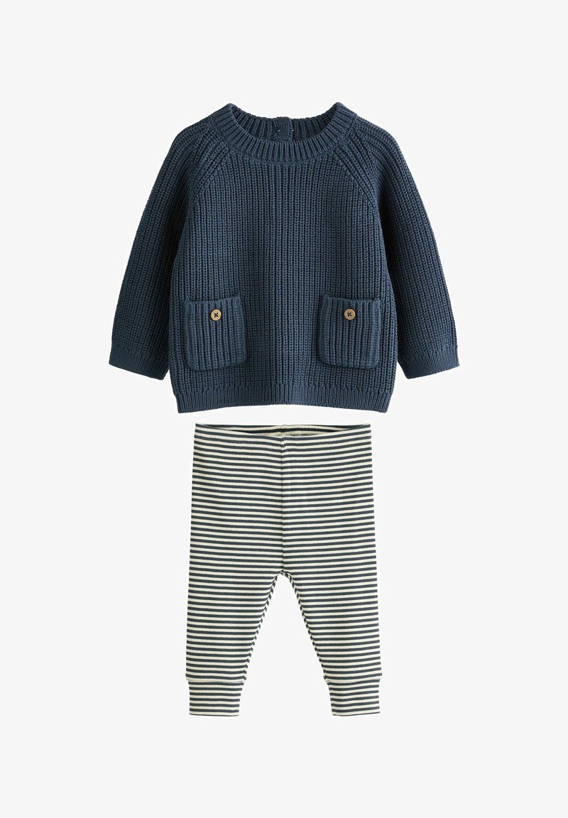 Marineblauer gestrickter Langarmpullover mit Fronttaschen und schwarz-weiß gestreiften Leggings für ein Baby oder Kleinkind.