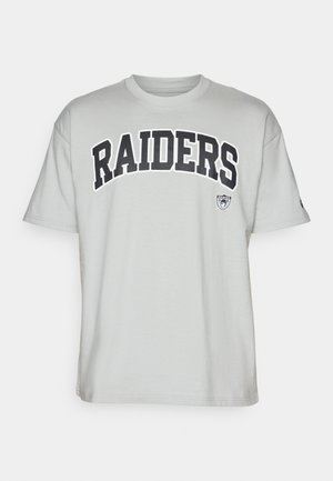 Szürke pamut póló, amelyen egy merész fekete "RAIDERS" felirat található a mellkason, és egy kis logó a bal ujján. Rövid ujjú és kerek nyakú.