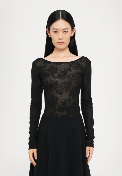 Body noir à manches longues en dentelle transparente avec des motifs floraux, présentant une encolure décolletée et une coupe ajustée.
