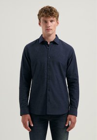 Navyblauwe button-up shirt van een zachte stof, met een standaardkraag, lange mouwen en een subtiele logo op de linkerkant van de borst.