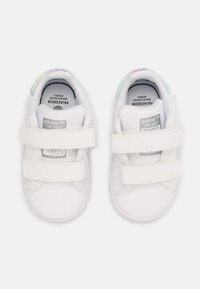 Sneakers sintetici bianchi con due cinturini in velcro, punta arrotondata e accenti iridescenti sul colletto. Presentano una soletta con marchio e un'etichetta logo.