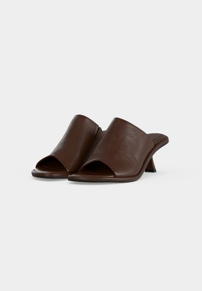 Dark brown leather open-toe mules with low curved block heels, slip-on style, shown angled on a plain light background.