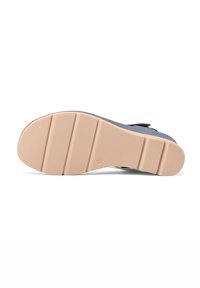La suola della scarpa presenta un materiale in gomma di un beige chiaro con una texture a motivo e cinque scanalature orizzontali per garantire aderenza.