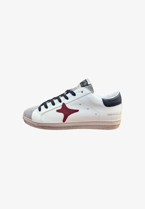 Sneaker bianca bassa con lacci neri, punta grigia, tallone blu navy, toppa a forma di stella rossa e suola beige con scritta "AMA-B/DELUXE" sul lato.