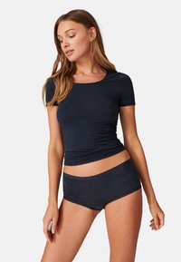 Top blu navy a maniche corte con scollatura a giro, abbinato a pantaloni corti hipster dello stesso colore. Tessuto morbido e texturizzato con dettagli di arricciatura sottili.