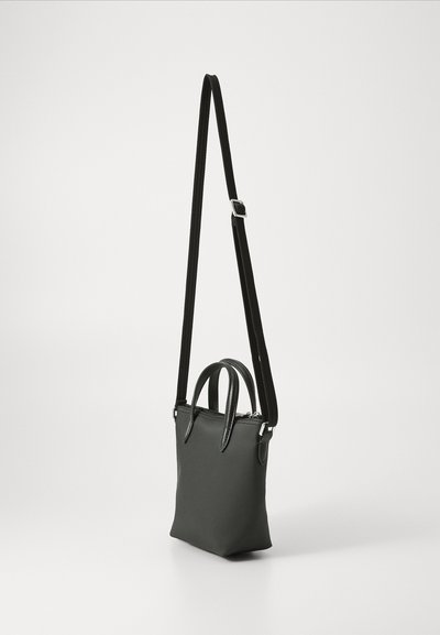 Sac fourre-tout noir texturé avec deux poignées supérieures et une bandoulière amovible et ajustable. Equipé de matériel en métal argenté et d'une fermeture éclair.