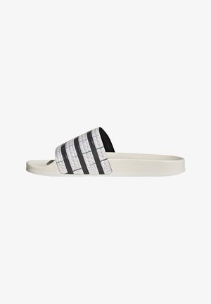Hvid slidesandal med tekstureret rem med tre sorte striber og flad sål, sideview.