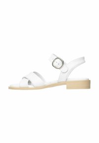 Sandale en cuir blanc avec des brides croisées, une boucle arrière pour un ajustement réglable et un petit talon block beige. Texture lisse et design minimaliste.