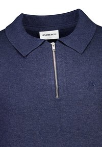 Mörkblå polo med dragkedjekrage, slim fit-design, stickad textur och broderad logga på vänster bröst.