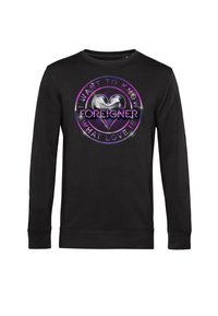 Sudadera negra con un diseño gráfico redondo que incluye el texto "QUIERO SABER QUÉ ES EL AMOR" y un corazón, acentuado en púrpura y plata.