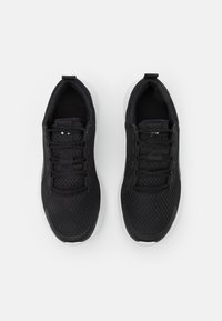 Chaussures de sport noires avec une tige en mesh respirant, des lacets texturés, un col rembourré et une semelle en caoutchouc blanche. Design plat sans aucune marque visible.