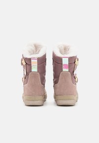 Stivali alla caviglia viola e marrone chiaro con una morbida fodera in pelliccia, fibbie ai lati e una suola in gomma texturizzata. Accent coloriato sul tallone.