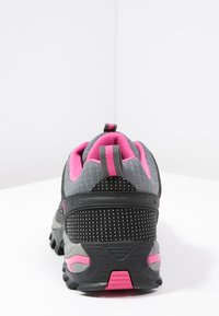 Black and gray athletic shoes featuring a textured upper, pink accents, and a cushioned sole, with a mesh fabric for breathability.