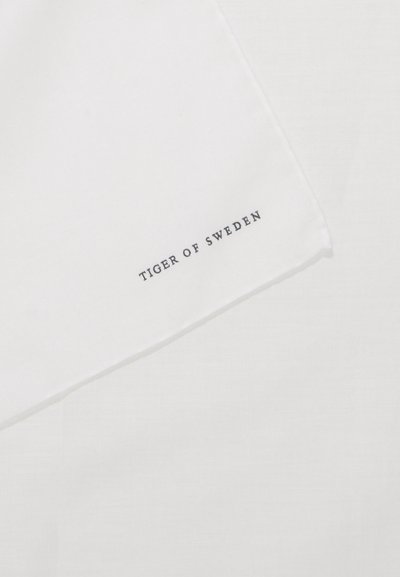 White cotton fabric with a textured surface, featuring the text "TIGER OF SWEDEN" printed in dark blue along the bottom edge.